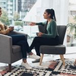 Shot of two young women drinking coffee while sitting together at home.